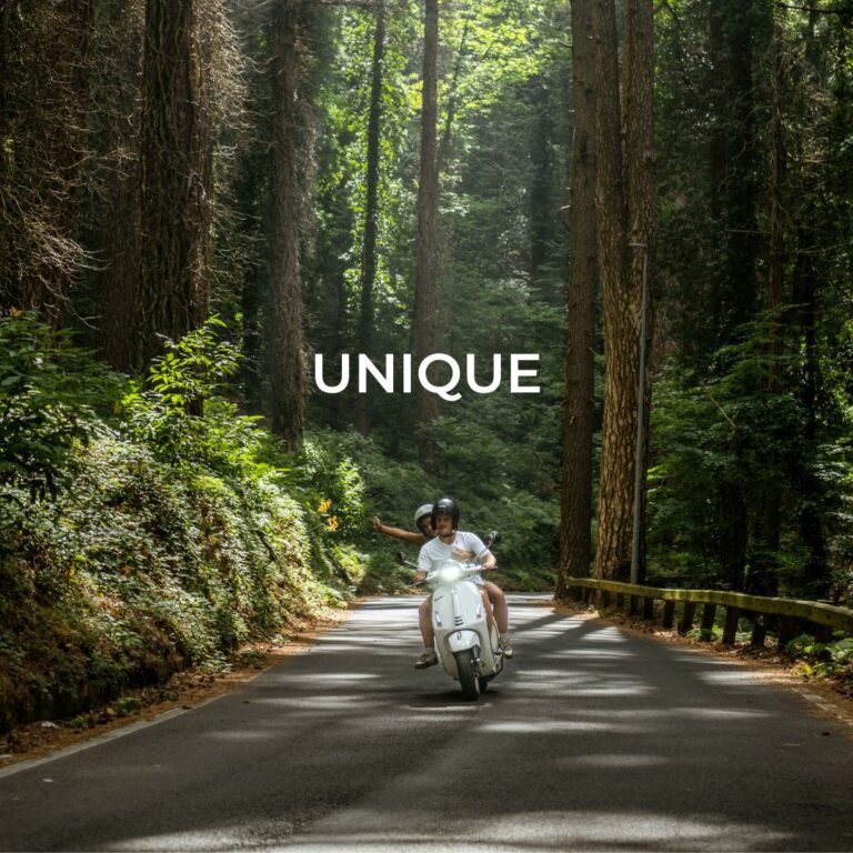 Zwei Personen fahren mit ihrer Vespa durch einen Wald an der Amalfiküste – ein unvergesslicher Italien Vespa Roadtrip.