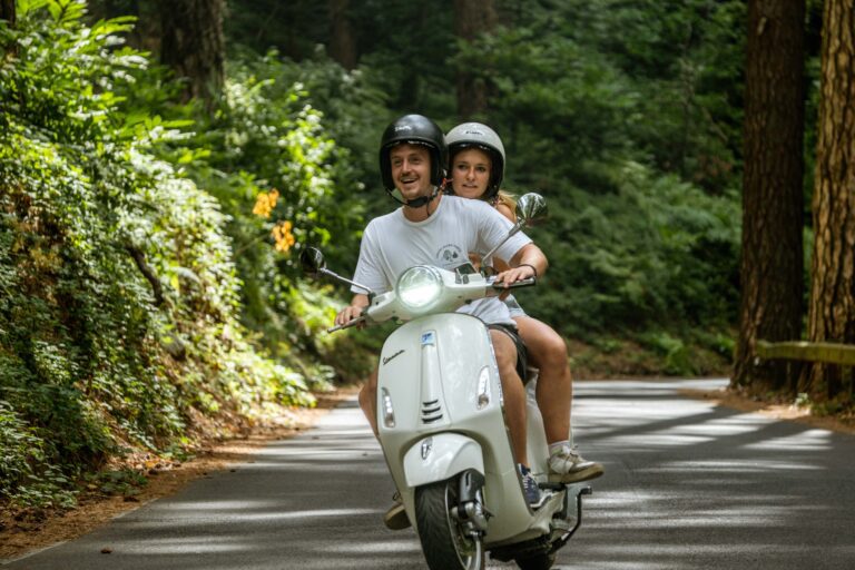 Paar, das während einer Vespa-Tour in Amalfi mit einer Vespa fährt.