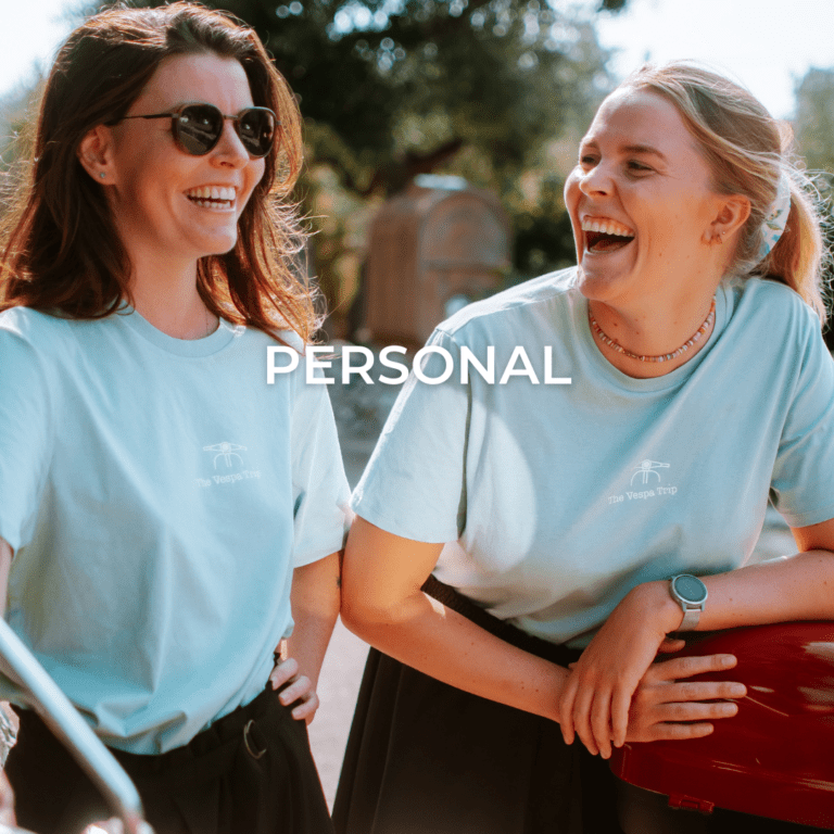 Zwei lachende Guides auf einer Vespa-Tour in Italien, bereit für das Abenteuer.