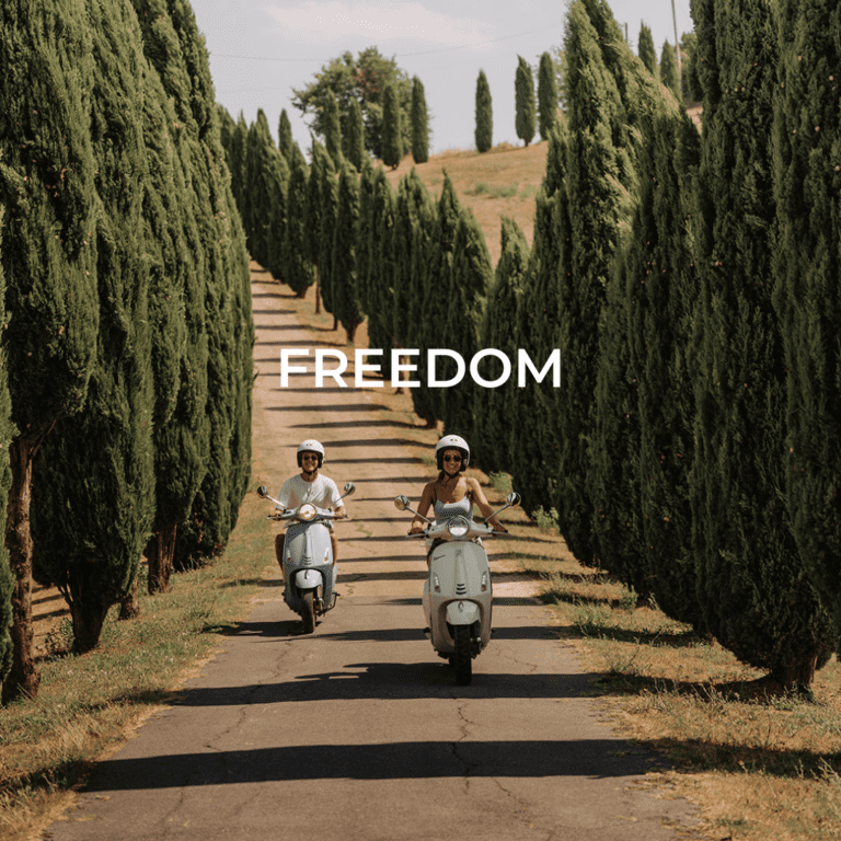 2 Personen auf einer Vespa in der Toskana zwischen den Weinbergen und Zypressen, zwei Personen auf der Vespa fahren durch eine malerische Landschaft in der Toskana, umgeben von Schirm-Pinienbäumen.